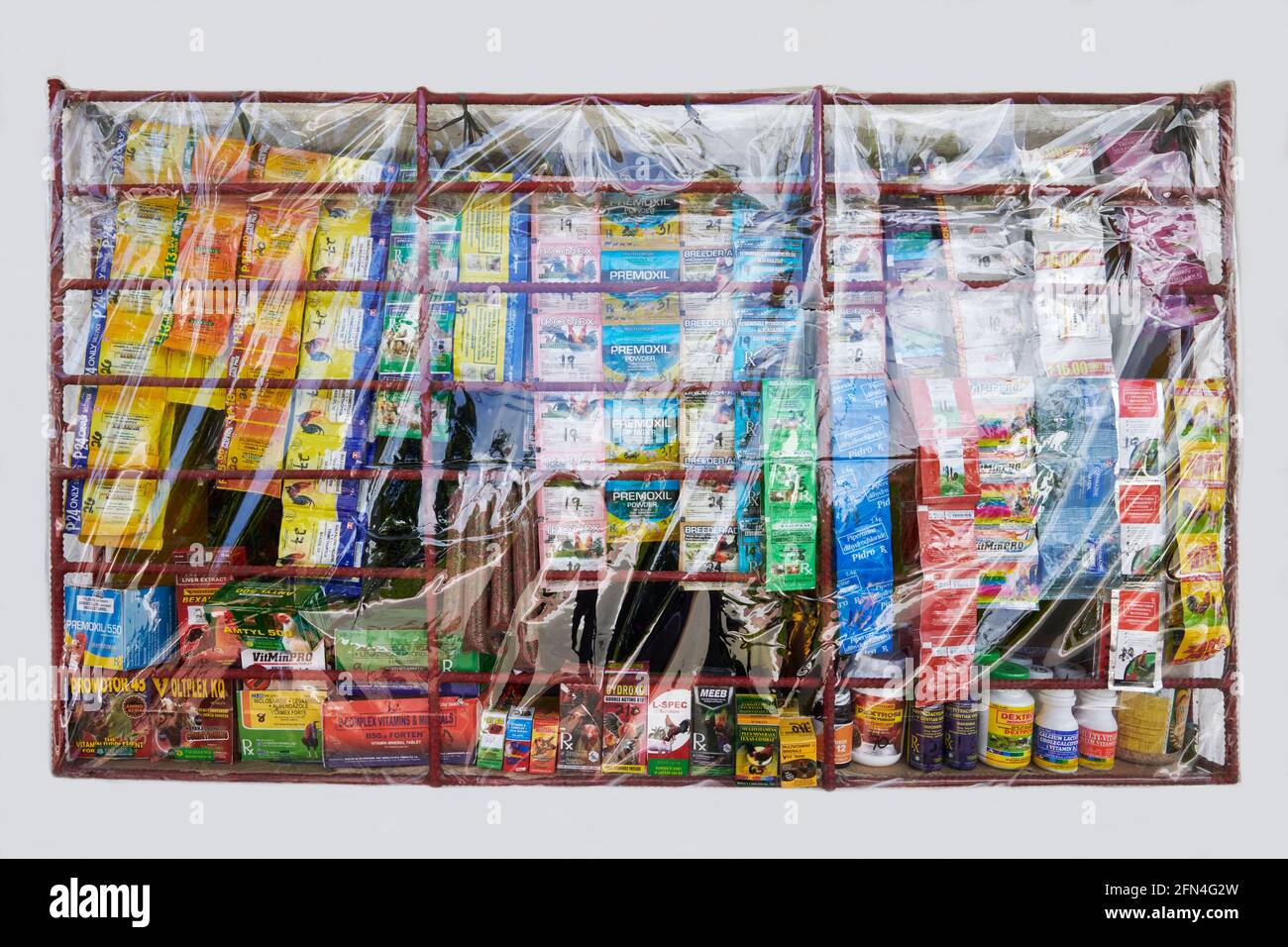 Grilled window of a neighborhood sari-sari store protected by plastic cover as a Covid precaution, selling veterinary medicines, Philippines Stock Photo
