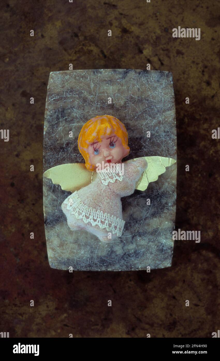 Model of fairy with orange hair big eyelashes and cardboard wings on marble block Stock Photo