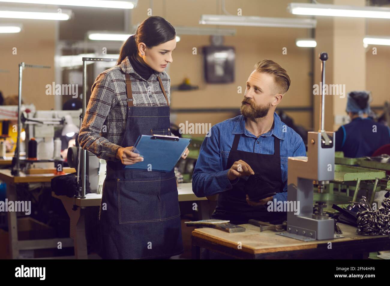 Shoe factory manager discussing the footwear production process with an