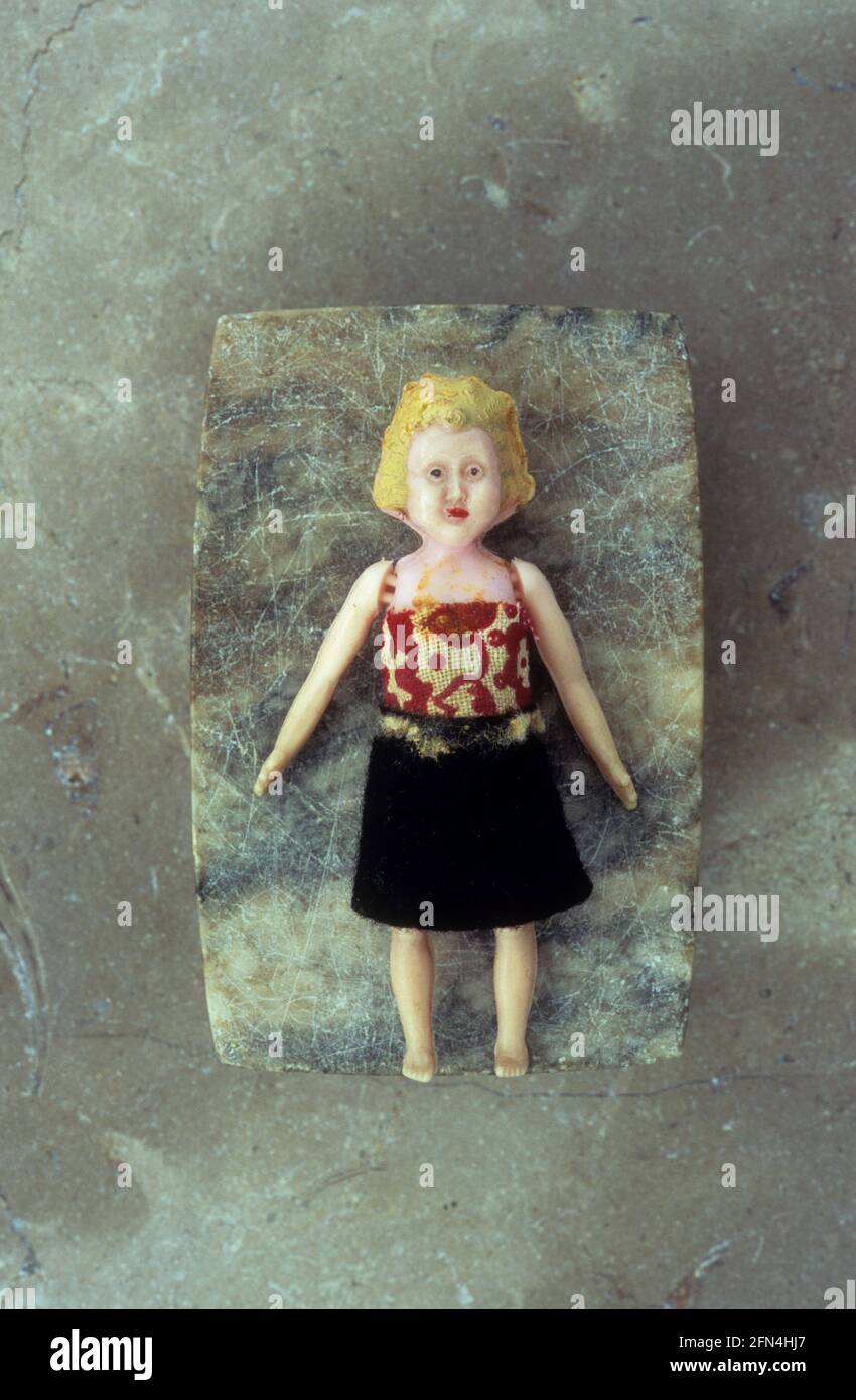 1960s woman doll dressed untidily with bewildered expression lying on marble Stock Photo