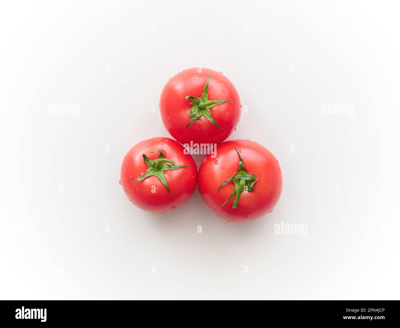 Three ripe tomatoes on a light gray ceramic surface. Top view. Not ...