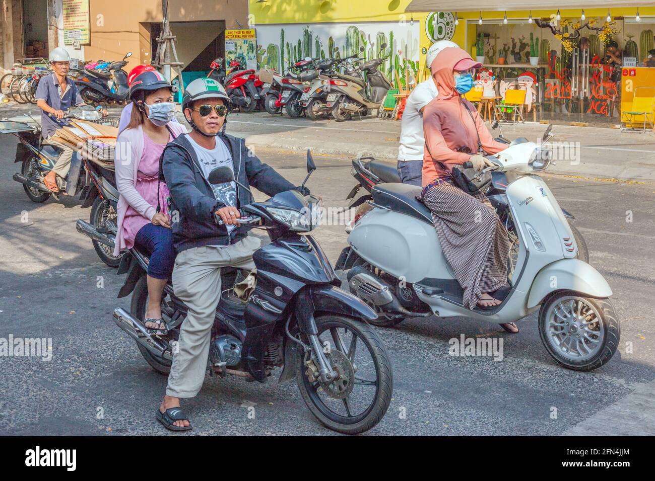 Vietnamese people on scooters and motorbikes waiting at road junction, Da Nang, Vietnam Stock Photo