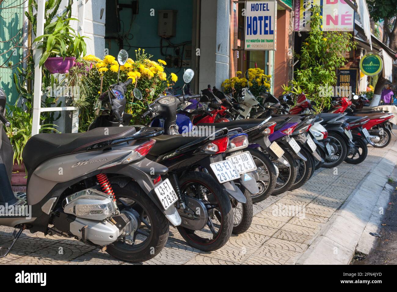 Vietnamese motorbikes and scooters blocking the pedestrian pavement so the public need to walk in road, Da Nang, Vietnam Stock Photo