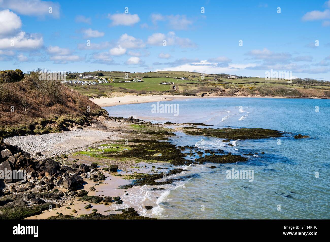 High view across rocky coast and bay to beach from coastal path. Lligwy, Isle of Anglesey, north Wales, UK, Britain Stock Photo
