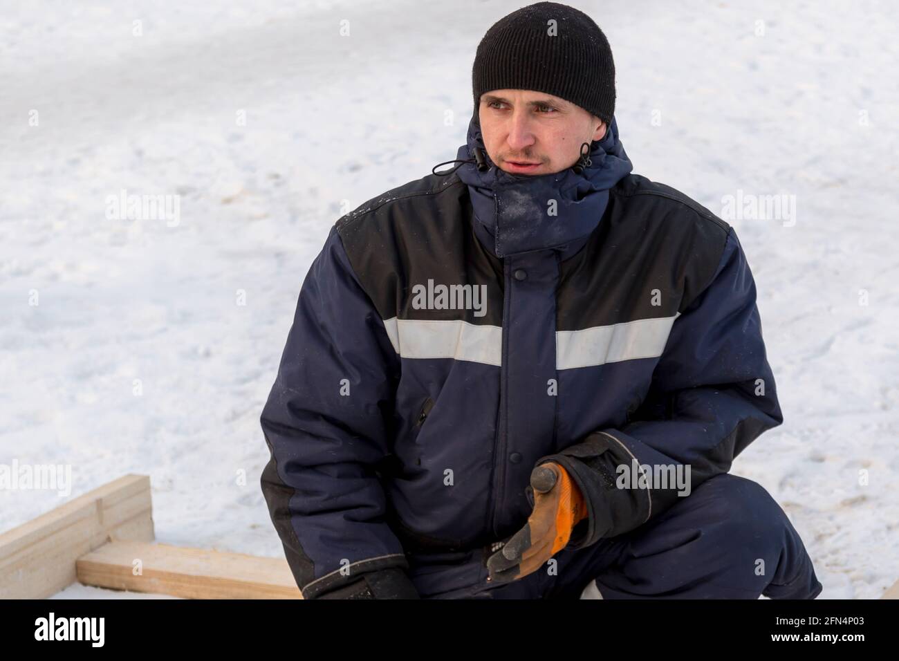 Portrait of a man in a blue winter jacket at the workplace Stock Photo