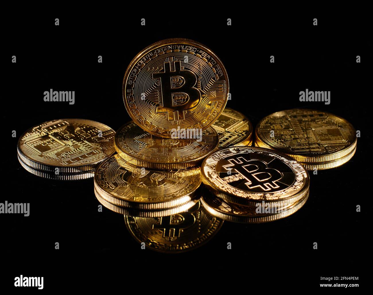 Closeup golden coin with bitcoin logo. Leader in cryptocurrency Bitcoin BTC  on a top of coins against black mirror surface. A heap of decentralized  Stock Photo - Alamy