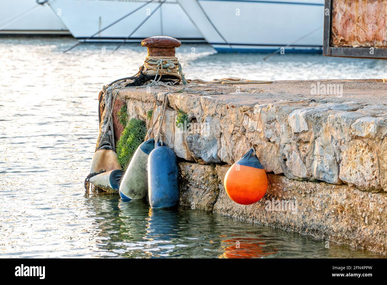 A seaport at sunset with bollard, ropes and fenders. Perfect shot for
