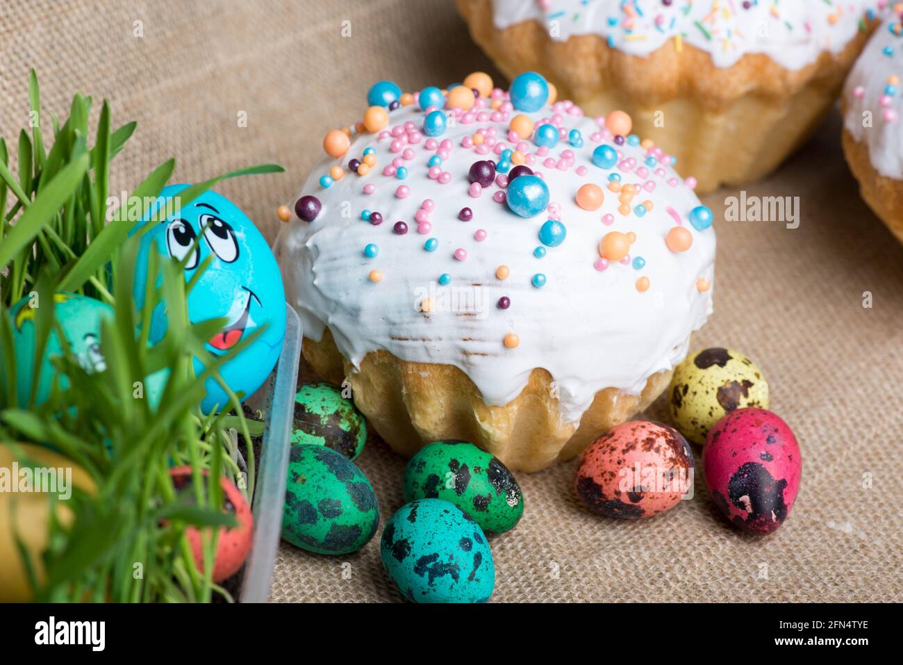big Easter cake and colored eggs lie on the background Stock Photo
