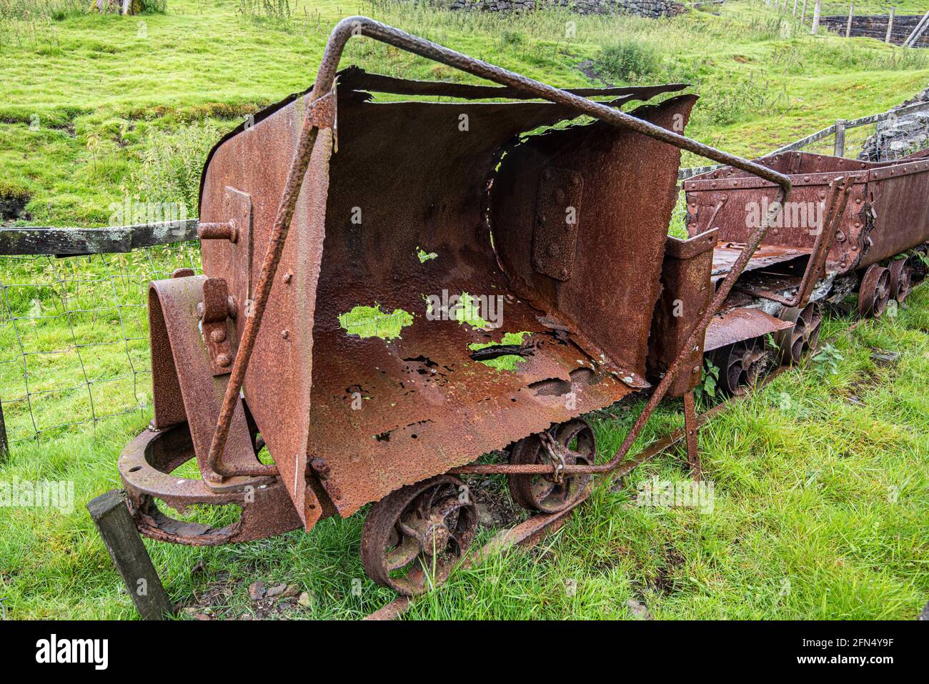 Old mining trucks rusting away at the entrance to an old historic lead mine at Wanlockhead in Scotland. Stock Photo