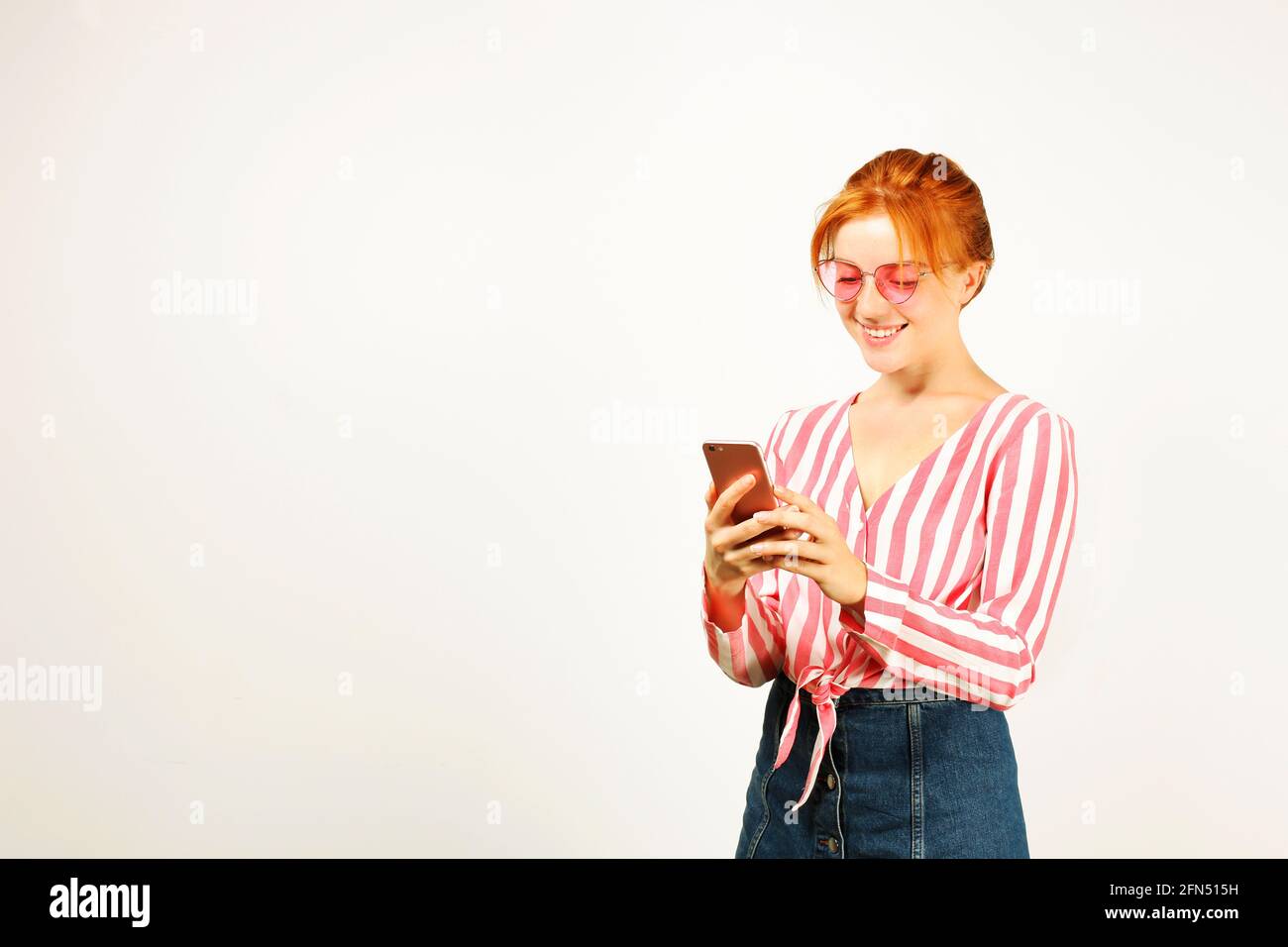 young-attractive-natural-redhead-woman-smiling-at-smartphone-screen