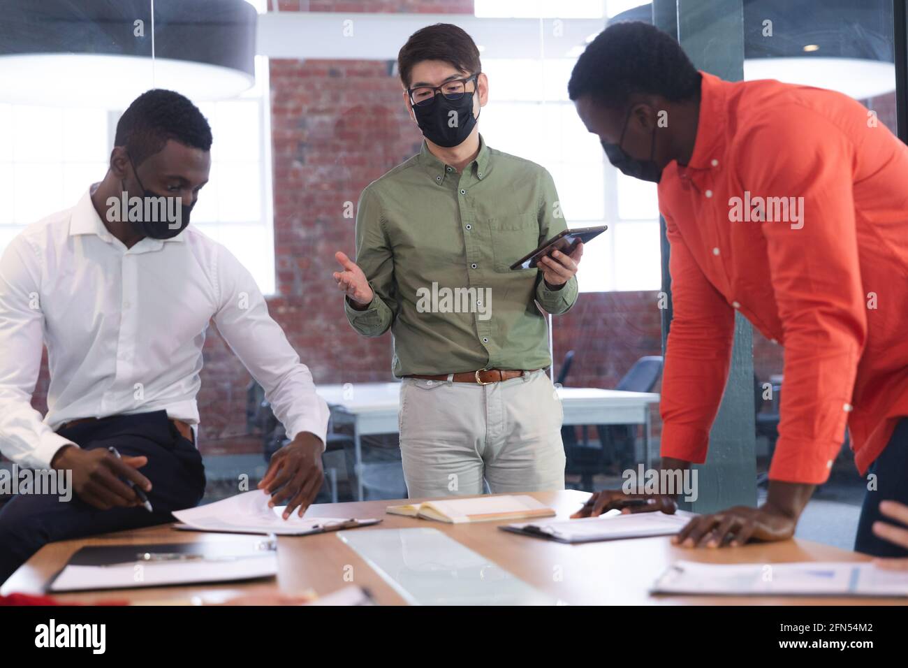 Team of diverse male and female office colleagues wearing face masks ...