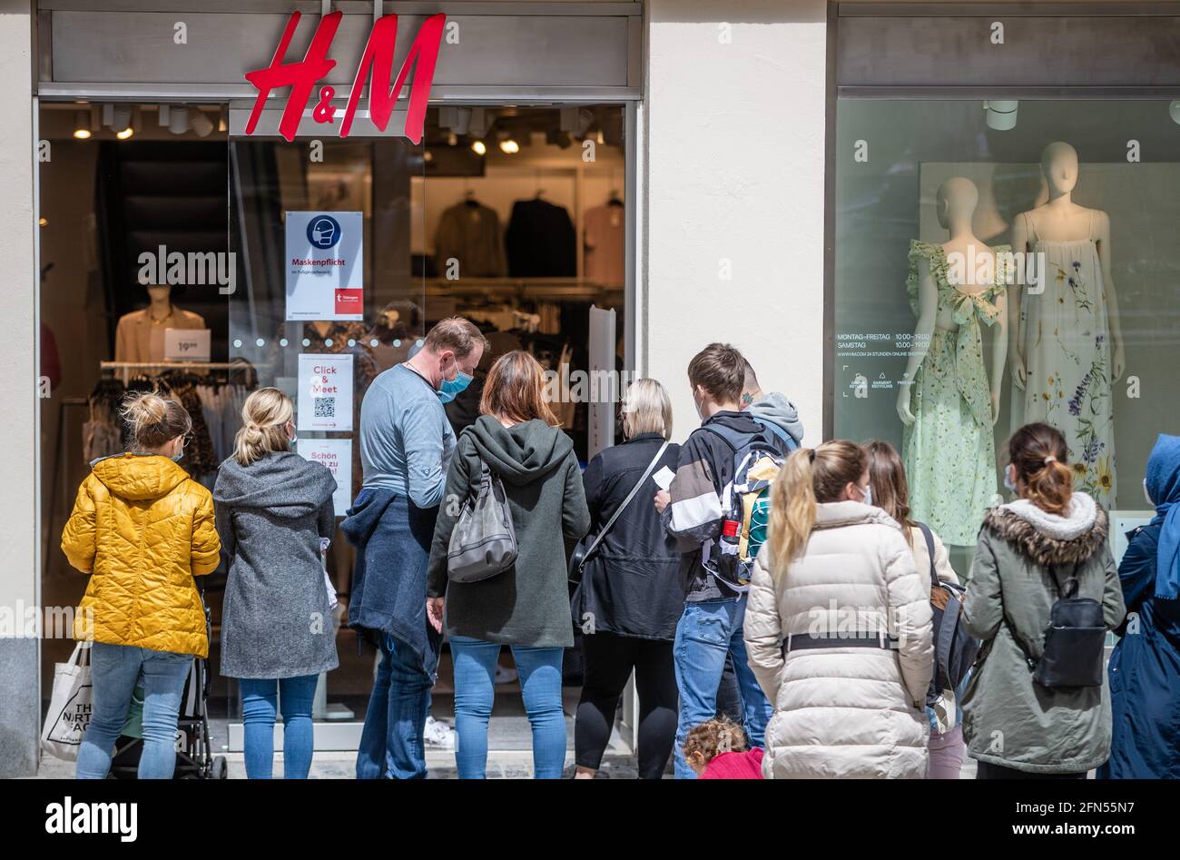 Tubingen, Germany. 14 May 2021: Customers line up outside a clothing store.  Stores that were closed for three weeks due to the "federal emergency  brake" are allowed to reopen for customers with