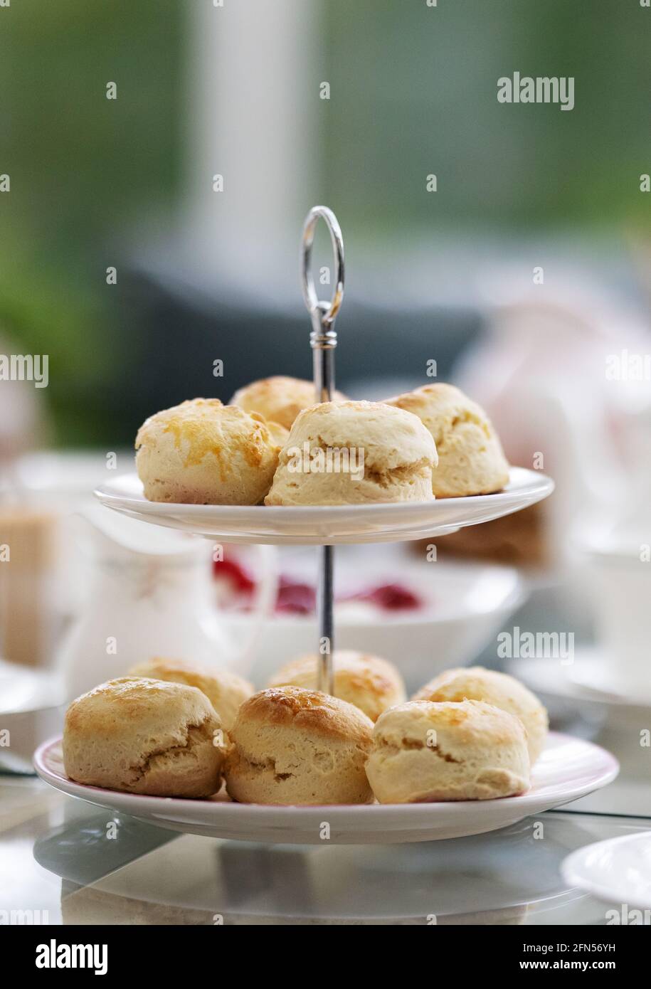 Scones served for a traditional english afternoon tea with bone china tea service and table laid; England UK Stock Photo