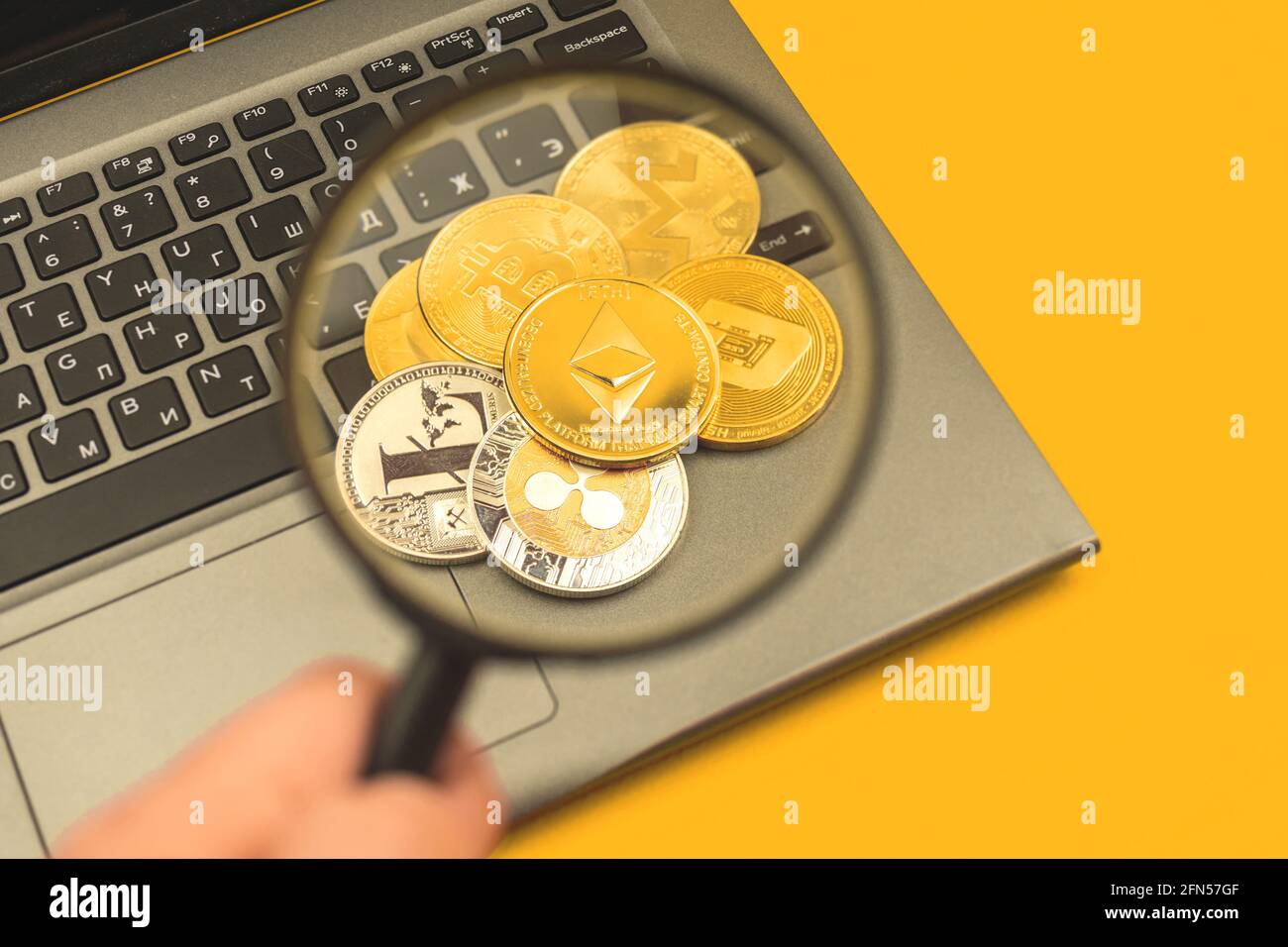Stack of crypto coins with Ethereum on top, man hold magnifying glass, crypto  currency financial and business background photo Stock Photo - Alamy