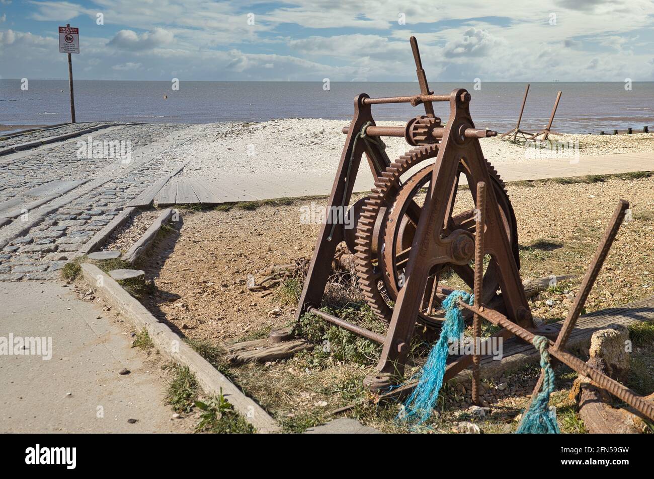 A rusty old winch used to pull boats up a slipway onto the beach at