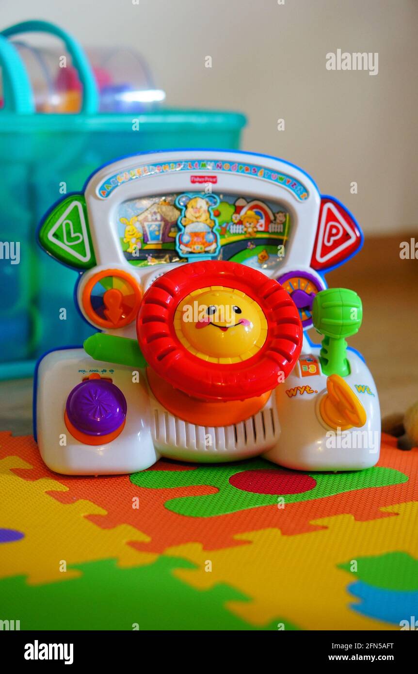POZNAN, POLAND - Jan 04, 2015: Colorful Fisher Price brand toy car  dashboard with steering wheel, switches and buttons on a floor Stock Photo  - Alamy