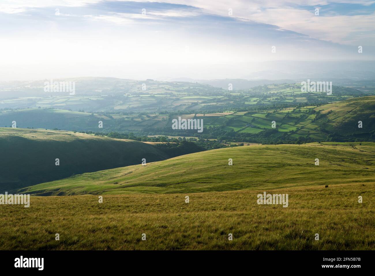 The rolling hills of Carmarthenshire in summer from Waun Lefrith in the Bannau Brycheiniog (formerly Brecon Beacons) National Park, South Wales. Stock Photo