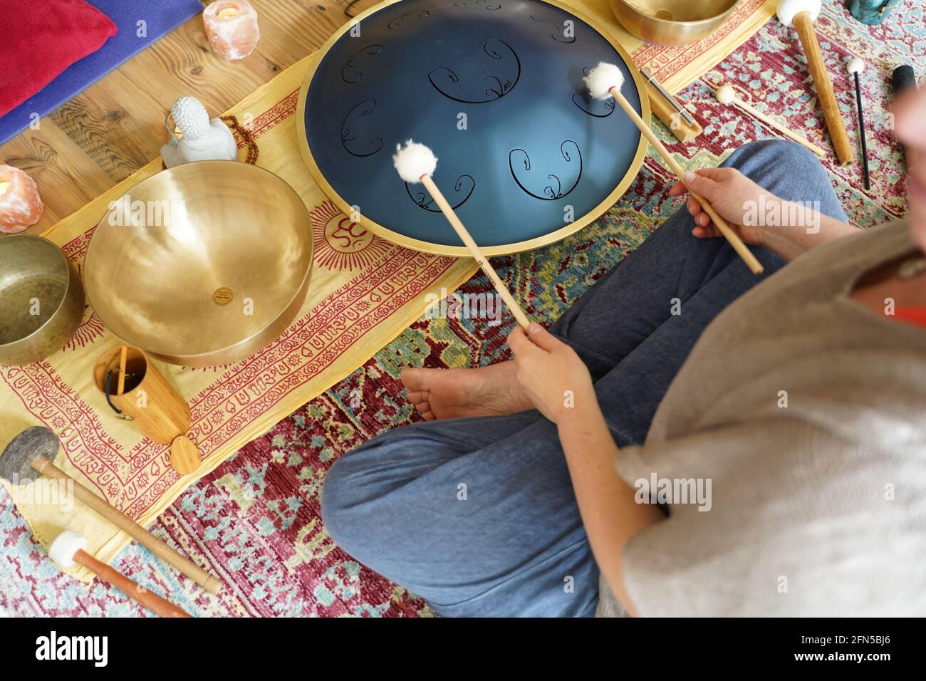 Woman with is playing a RAV Drum, close up of womans hands playing hang drum, music instrument for sound healing.Woman is playing a RAV Drum Stock Photo