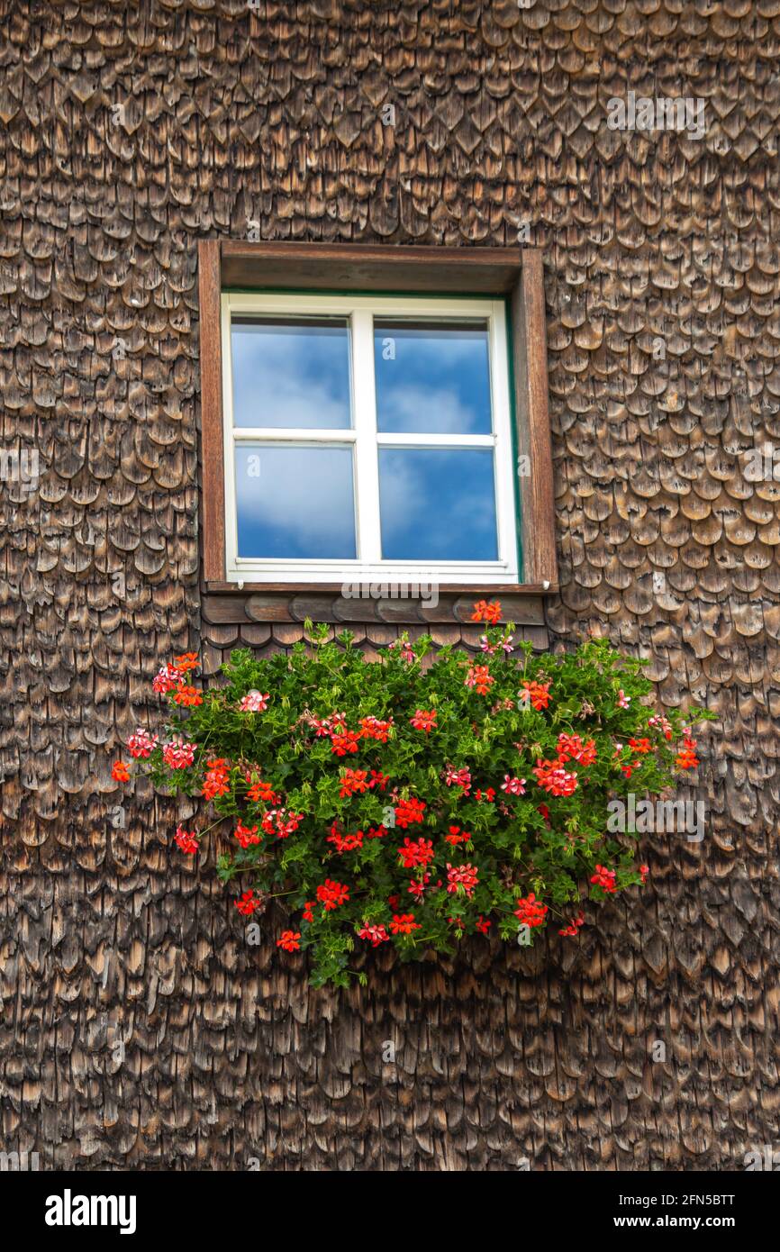 view of window with blue sky in old weathered wooden traditional rustic alpine facade in Kurzras, Val Senales, South Tyrol, Italy Stock Photo