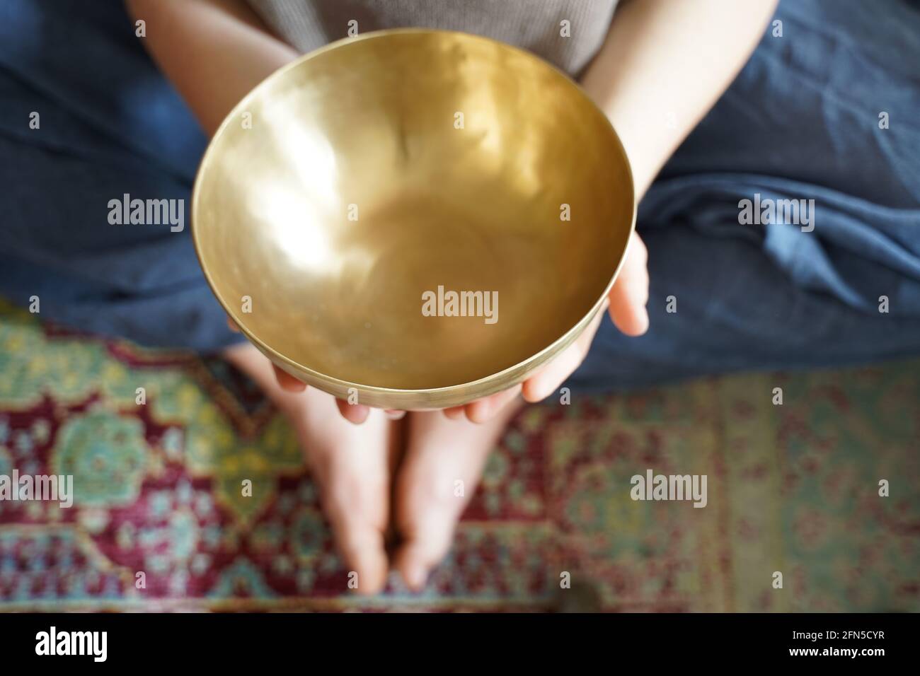 Caucasian woman holding a Tibetan singing bowl in her hand for sound healing therapy Stock Photo