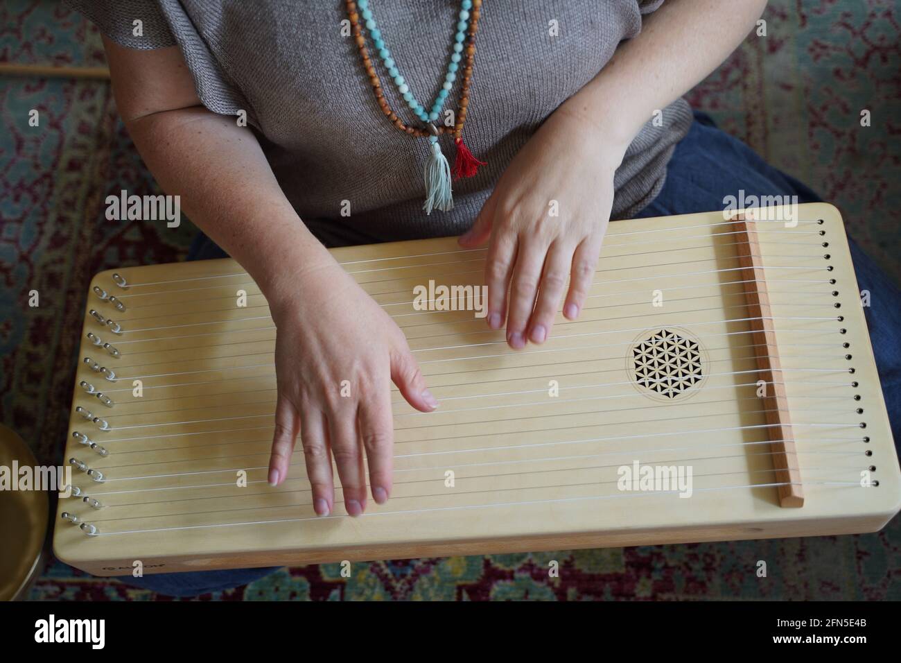 Woman holding a monochord, sound healing instrument in a therapy session. Stock Photo