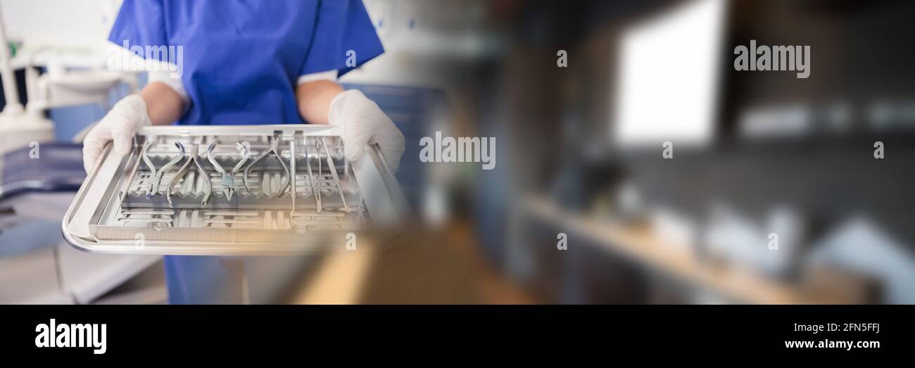 Composition of midsection of female dental nurse holding tray with tools with blurred light trails Stock Photo