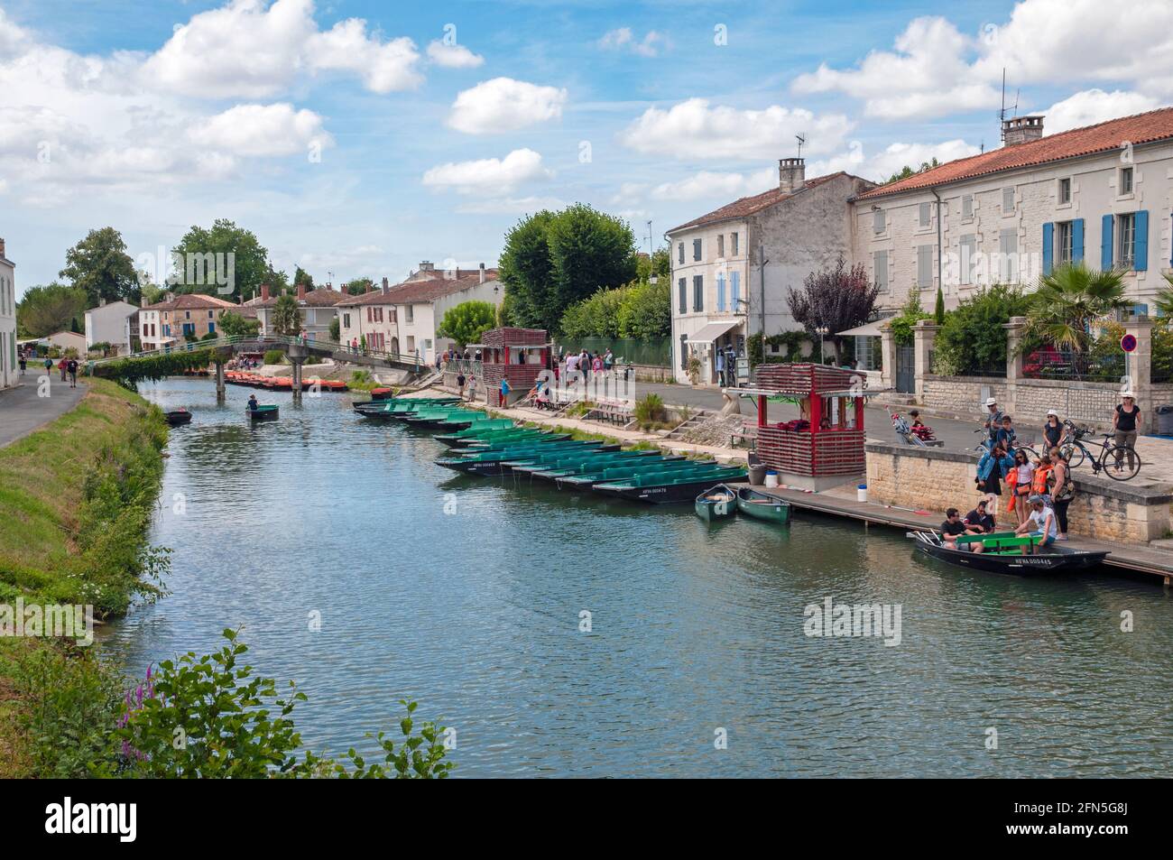 Green tourist pleasure boats on the Sevre Niortaise river in the picturesque town of Coulon, Deux-Sevres (79) in the Marais Poitevin, the largest mars Stock Photo