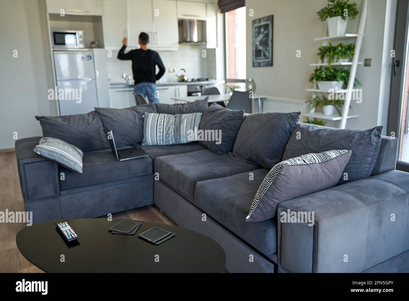 Modern stylish interior of the apartment. Man cooking in the kitchen ...