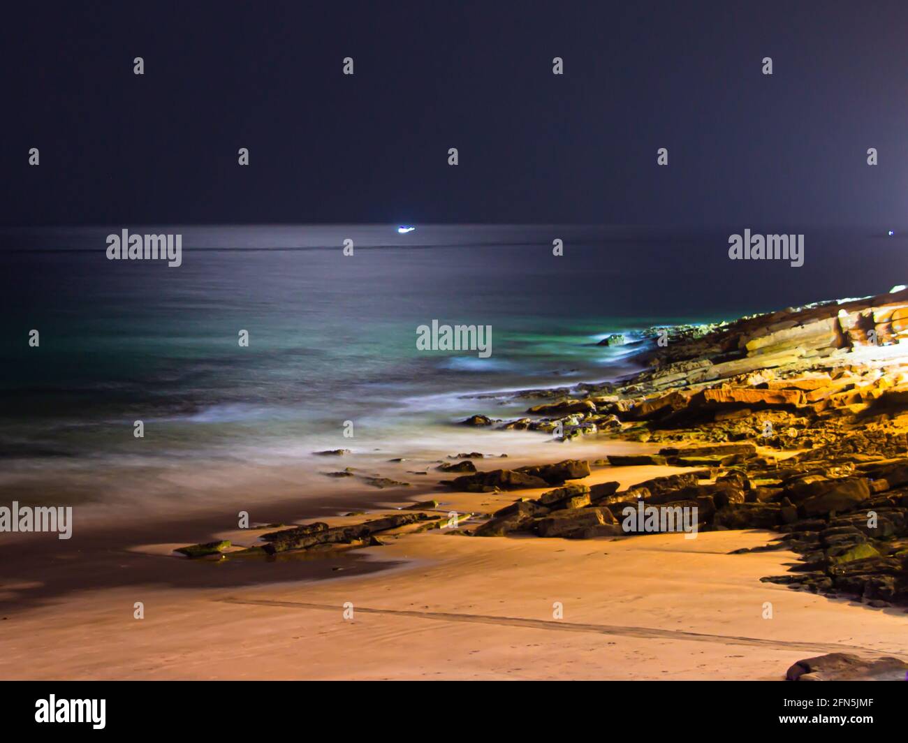 Seascape by night and moonlght reflection in the middle of the sea in Taghazout Beach Stock Photo