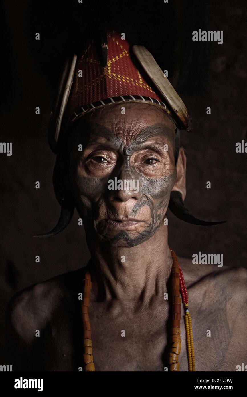 The chief of a Konyak village is known as an Angh. INDIA: FASCINATING portraits have captured the few remaining headhunters of a remote Indian tribe. Stock Photo