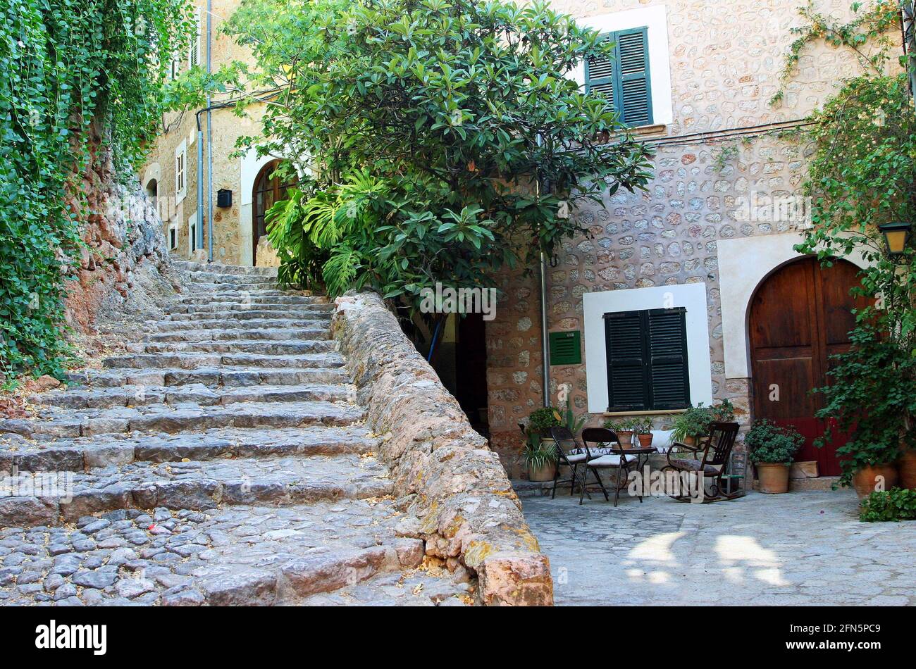 A courtyard in the centre of Fornalutx, a hill village in the Tramuntana mountains on the Balearic island of Mallorca, Spain. Early morning, September Stock Photo