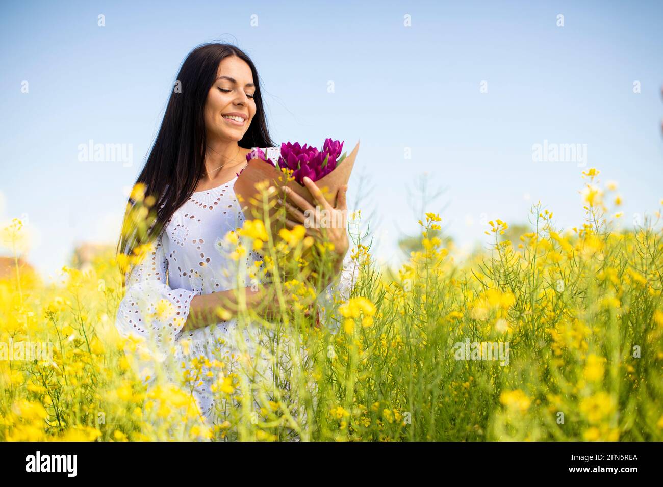 Pretty young woman in the rapeseed field Stock Photo - Alamy