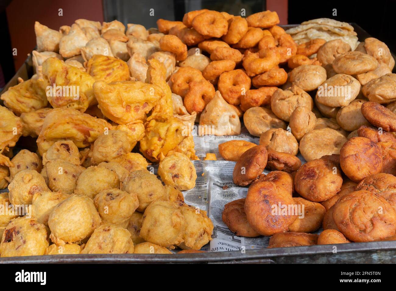 Cuttack, Odisha, India - 24th July 2019 : Piiyaji, bara, aloo chop etc, are being sold by cart puller called thelawalla , street foods of Odisha. Stock Photo