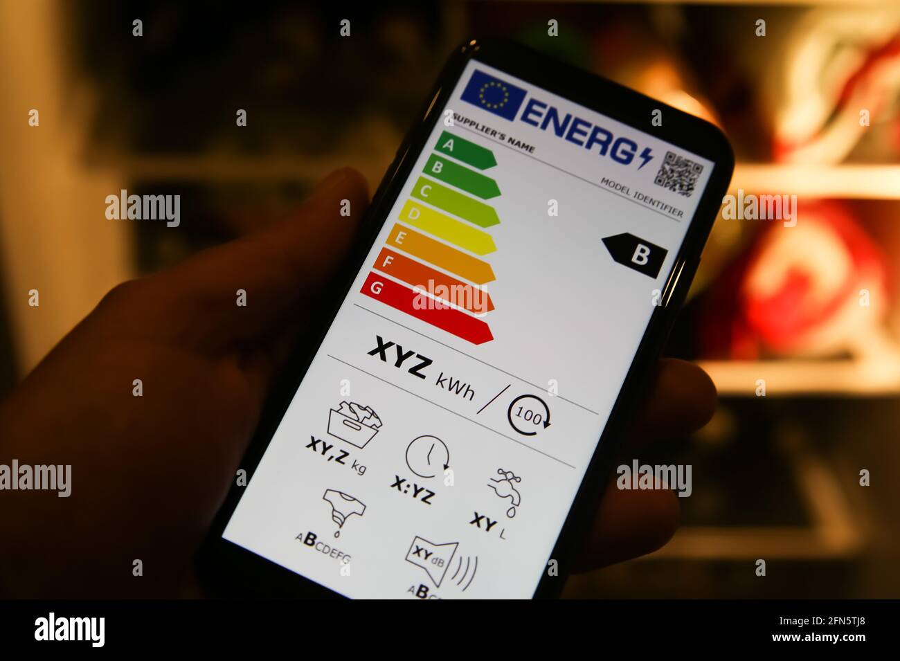 Viresen, Germany - May 8. 2021: Closeup of mobile phone screen with new european union energy label efficiency classes A - D, blurred fridge backgound Stock Photo