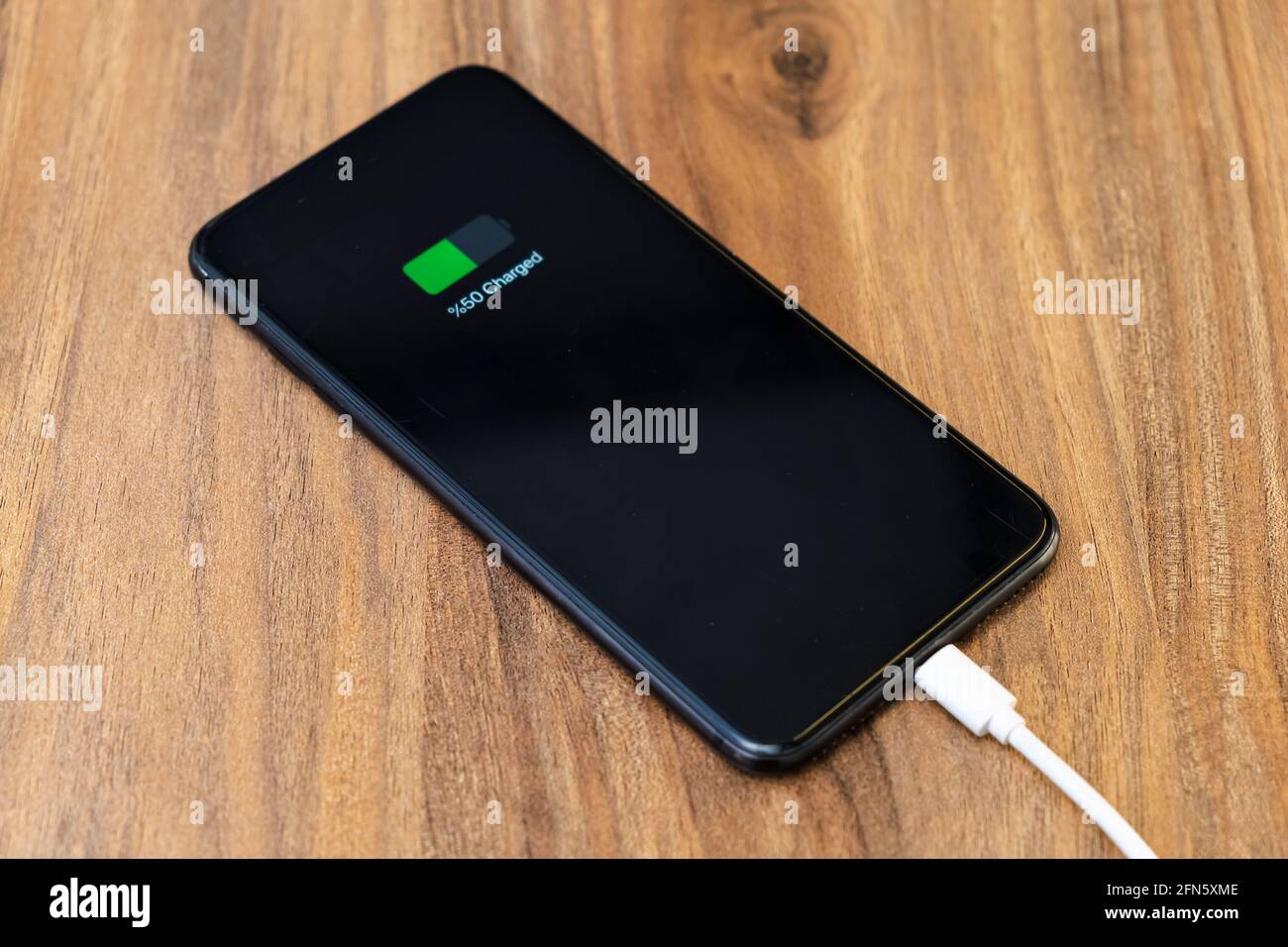 smartphone battery charging showing half charged battery on fast cable