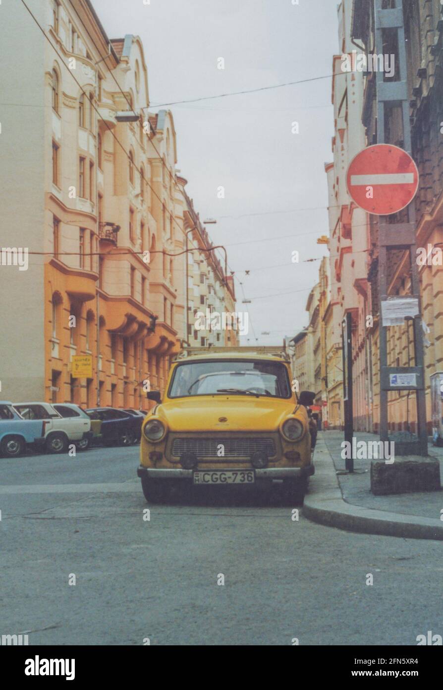 A yellow East German Trabant car or also known as Trabbi parked in a street in Budapest, Hungary, Europe - archival image Stock Photo