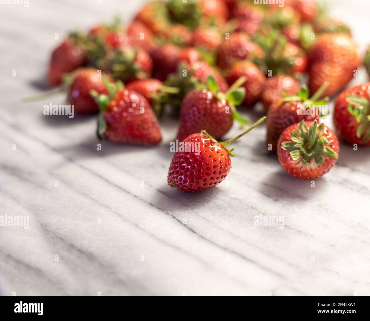 Pile of Strawberries on White Marble Stock Photo Alamy
