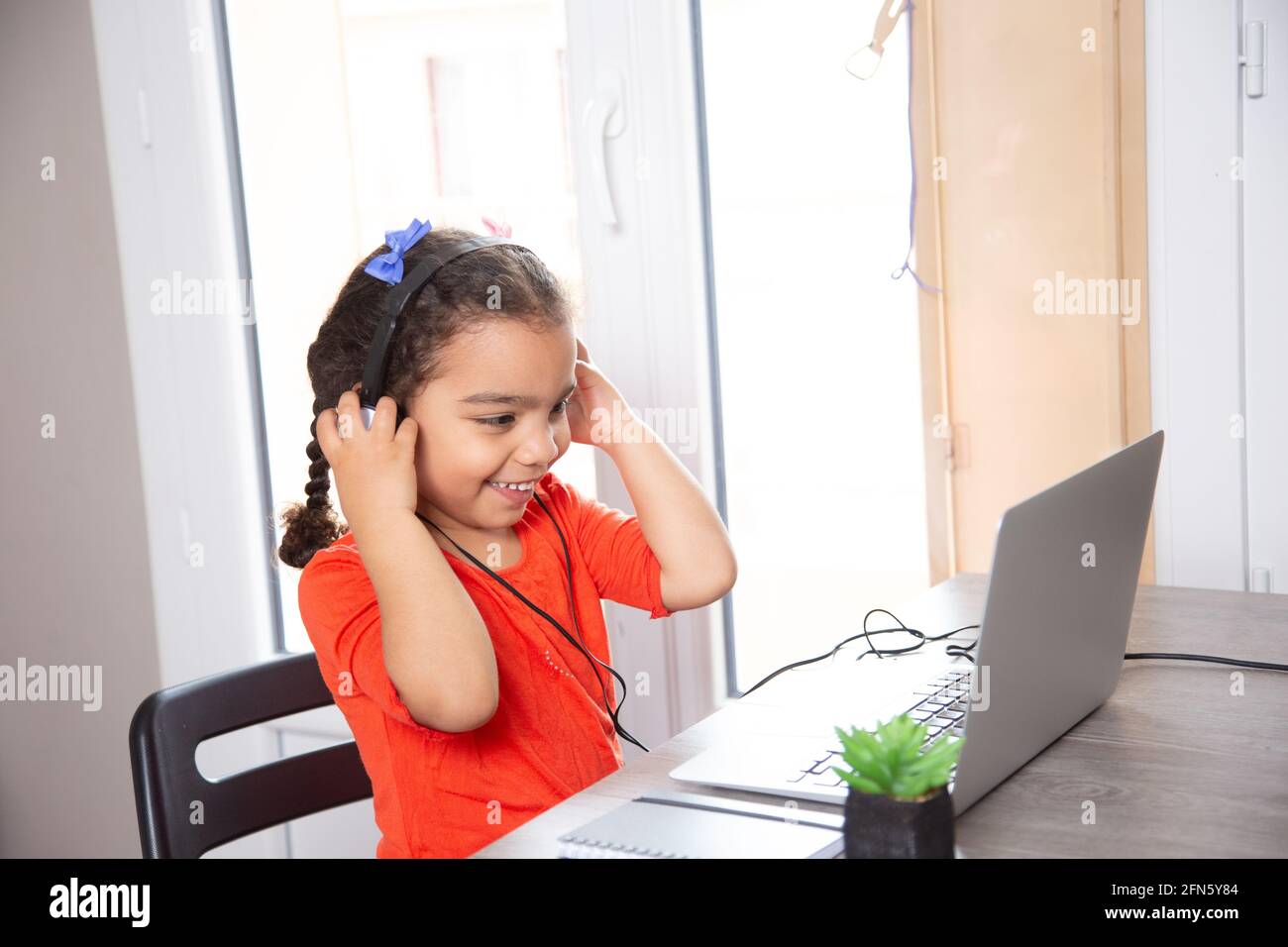 baby studying at home with his laptop and headphones . distance ...