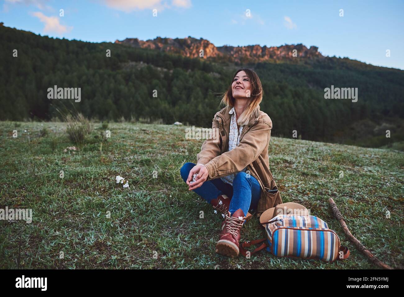 A happy woman in the mountains.She throws some flowers. Stock Photo