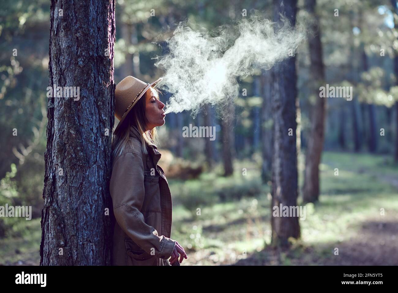 Woman on the mountain. She is in a forest with pine trees Stock Photo ...