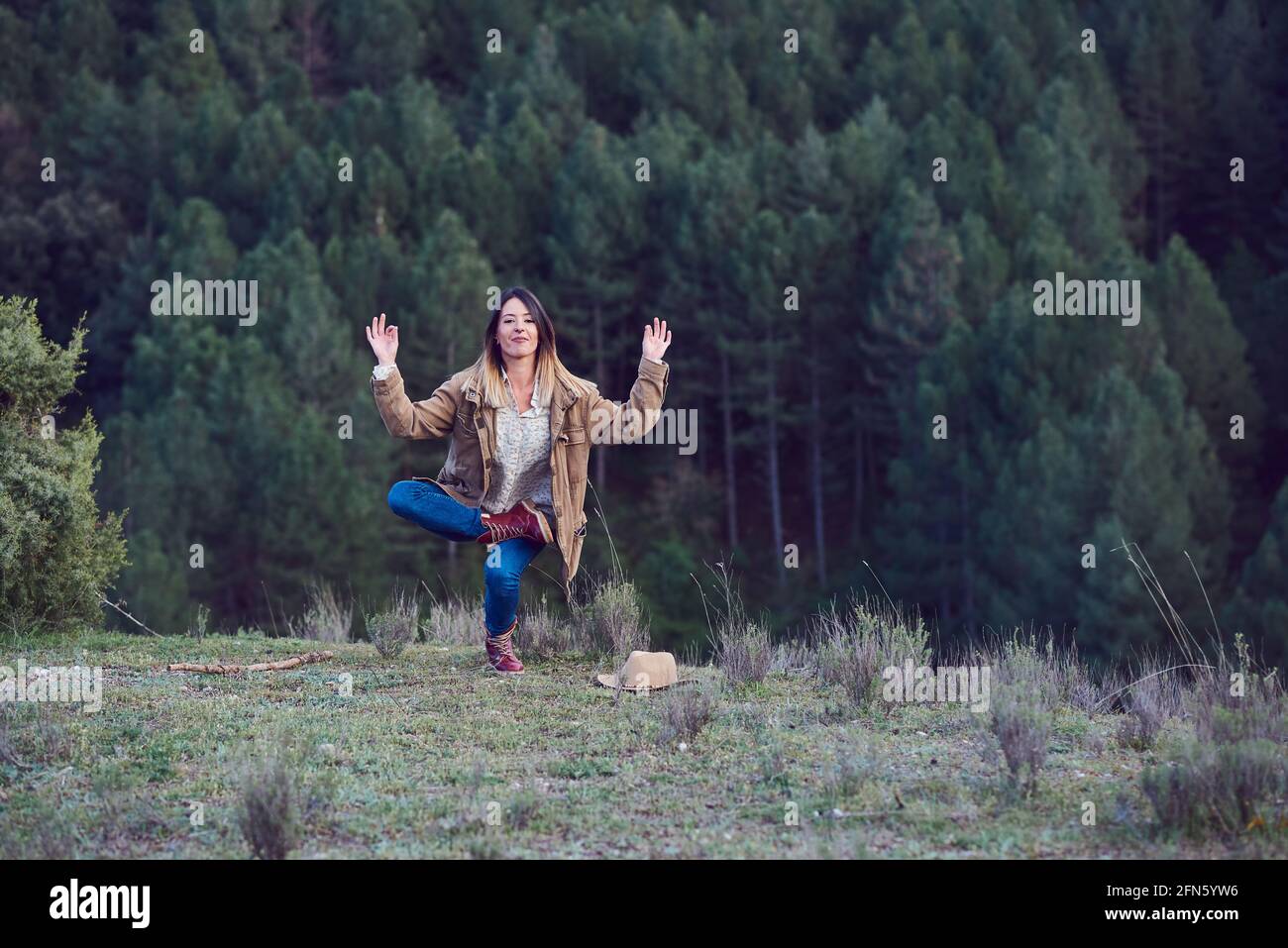 Woman on the mountain. She is in a forest with pine trees Stock Photo ...