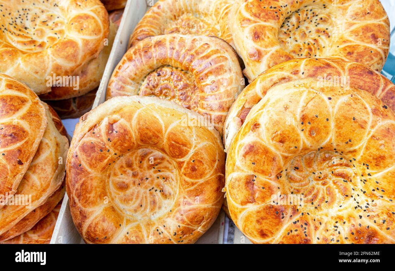 Fresh uzbek flat breads with sesame seeds from the tandir. Traditional eastern flat bread. Concept of national cuisine Stock Photo