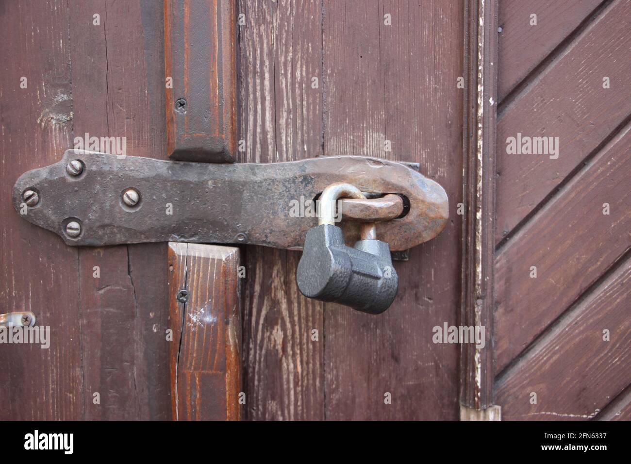Hanging lock on brown ancient vintage door. locked old wooden door. Confidential information security concept. Stock Photo