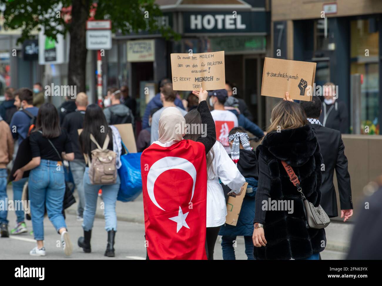 Demonstrantin mit Türkei Flagge: ' Du musst kein Moslem sein, um dich für Palästina einzusetzen! Es reicht Mensch zu sein! ' Demonstrantin hält ein Schild mit der Aufschrift: ' Save Sheikh Jarrah '. Ca. 1000 Menschen versammelten sich am 14. Mai in München, um ihre Solidarität mit den Palästinenser*innen und den Menschen in Gaza zu zeigen. * Demonstrator wearing a Turkey flag: ' You don't have to be a muslim to show commitment for Palestine! You only have to be human! ' Demonstrator holds sign reading: ' Save Sheikh Jarrah '. Around 1000 people spontaneosly gathered on May 14, 2021 in Munich Stock Photo
