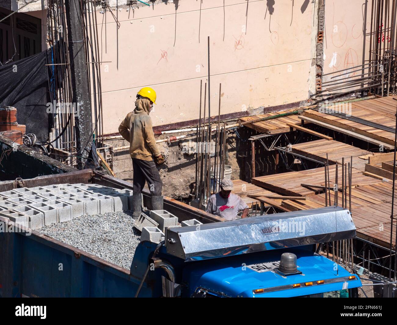 Medellin, Antioquia, Colombia - December 23 2020: Brown Men with Yellow Helmets Working on a Building Construction Site Stock Photo