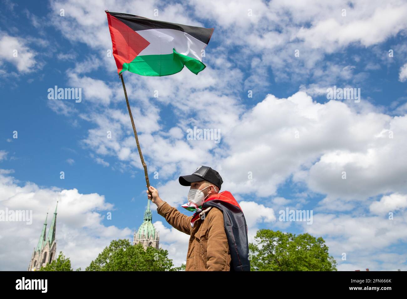 Demonstrant hält Palästina Flagge in den Himmel. Ca. 1000 Menschen
