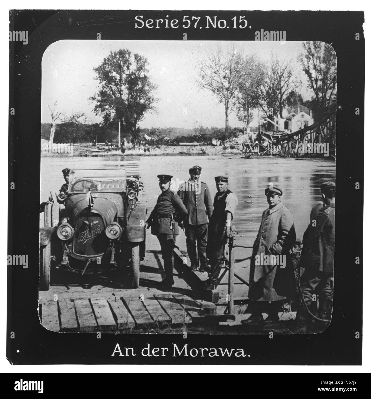 Projection für Alle - Die Eroberung Serbiens. Serie 57. No 15. An der Morawa. Der Fluß Morava war im Oktober 1915 Schauplatz des Vorrückens deutscher Truppen. Die Aufnahme zeigt eine einfache Fähre, darauf ein 'Horch' PKW. Daneben eine zerstörte Brücke. Die Firma „Projection für Alle“ wurde 1905 von Max Skladanowsky (1861-1939) gegründet. Sie produzierte bis 1928 fast 100 Serien zu je 24 Glasdias im Format 8,3 x 8,3 cm im sog. Bromsilber-Gelatine-Trockenplatten Verfahren. Die Serien umfassten Städte, Länder, Landschaften, Märchen und Sagen, das Alte Testament u. den 1. Weltkrieg. Stock Photo