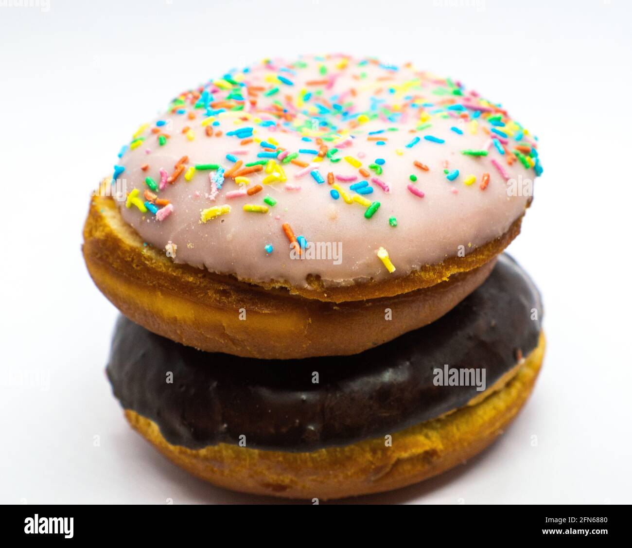Chocolate doughnut over a doughnut with powdered sugar colored on background.  Stock Photo