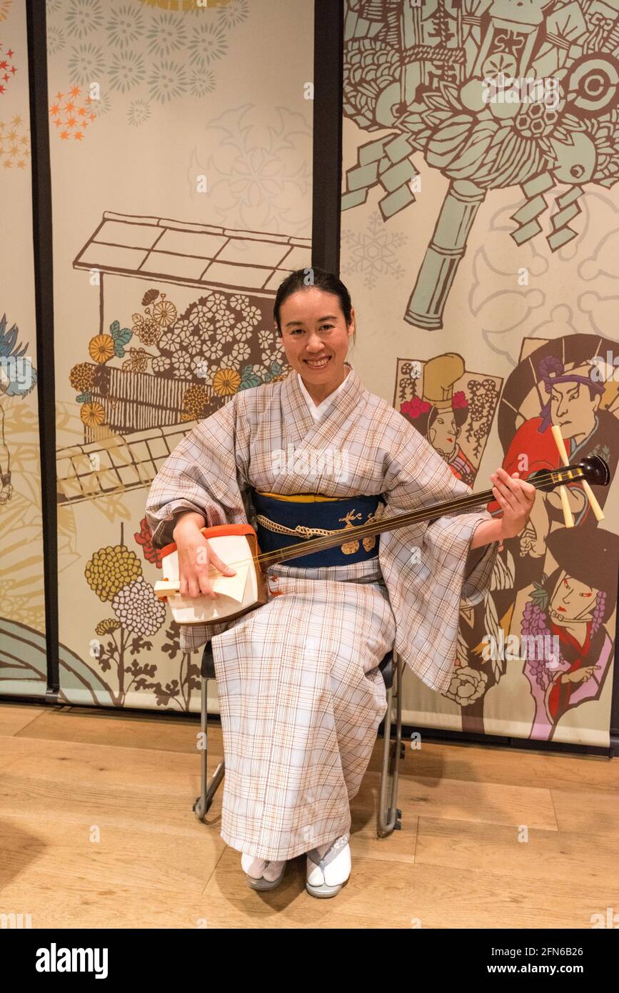 Tokyo, Japan - January 10, 2016: Japanese tourist dressed in a traditional japanese kimono holding a  Shamisen instrument at the Asakusa Culture Touri Stock Photo
