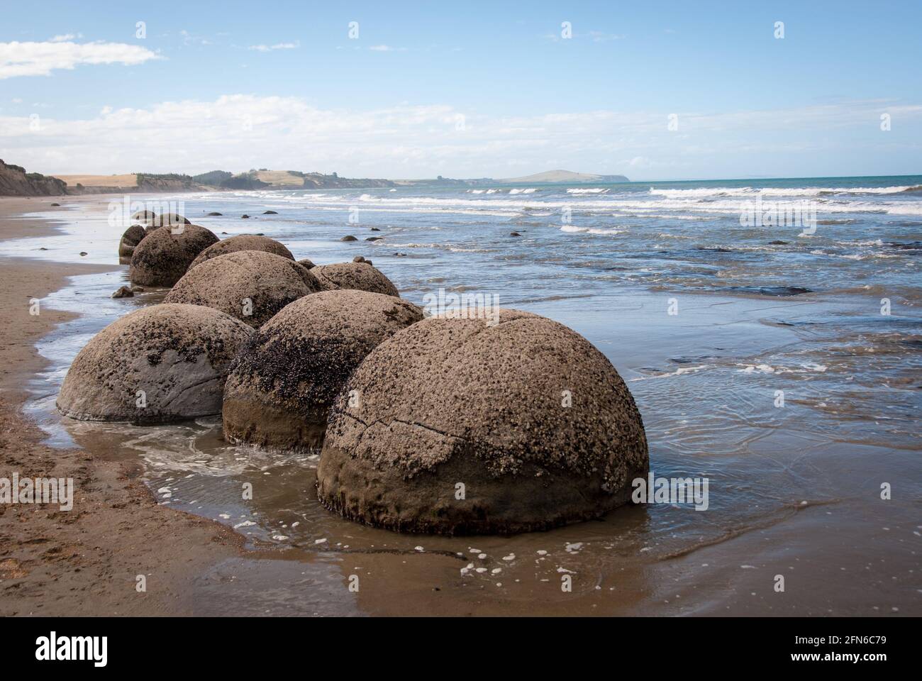 Lost marbles of a giant? A number of the Moeraki Boulders at Koekohe Beach on New Zealand's South Island lie in the surf zone. Stock Photo